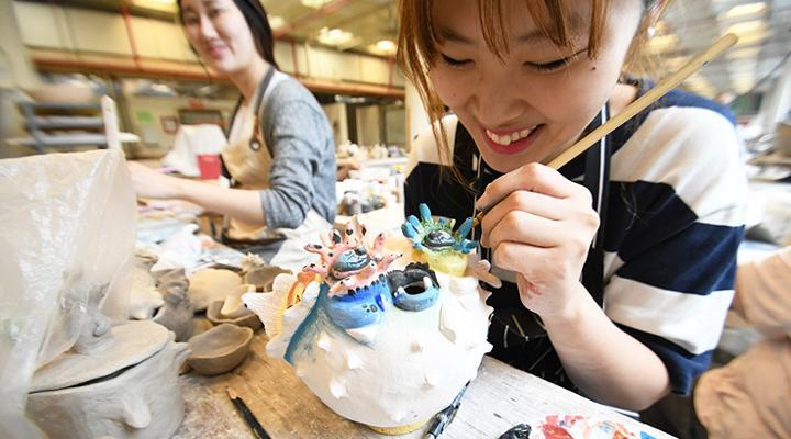 Two people working on art projects smiling and laughing